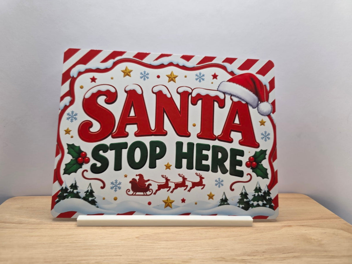 Santa Stop Here red and white Christmas metal sign displayed with its white stand