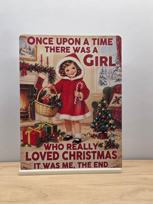 Once Upon a Time girl who loved Christmas metal sign showing a girl in a red coat with a candy cane and gift basket in a white stand