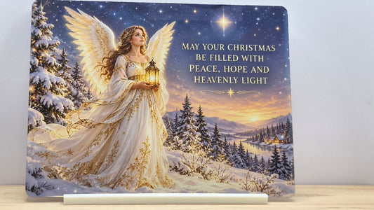 Christmas angel holding a lantern in a snowy landscape with peace, hope and heavenly light wording