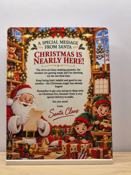 Christmas Is Nearly Here metal sign with a Santa message, Father Christmas, elves and a festive workshop, displayed in a white stand