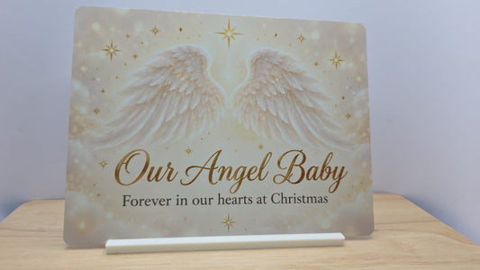 Our Angel Baby Christmas memorial metal sign with white wings and gold stars in its free stand
