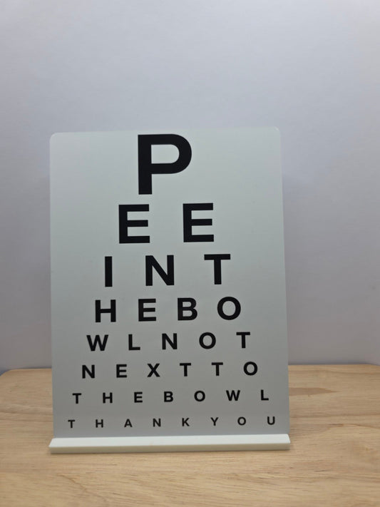 Real photo of Pee Into the Bowl black and white funny bathroom eye test metal sign with white stand
