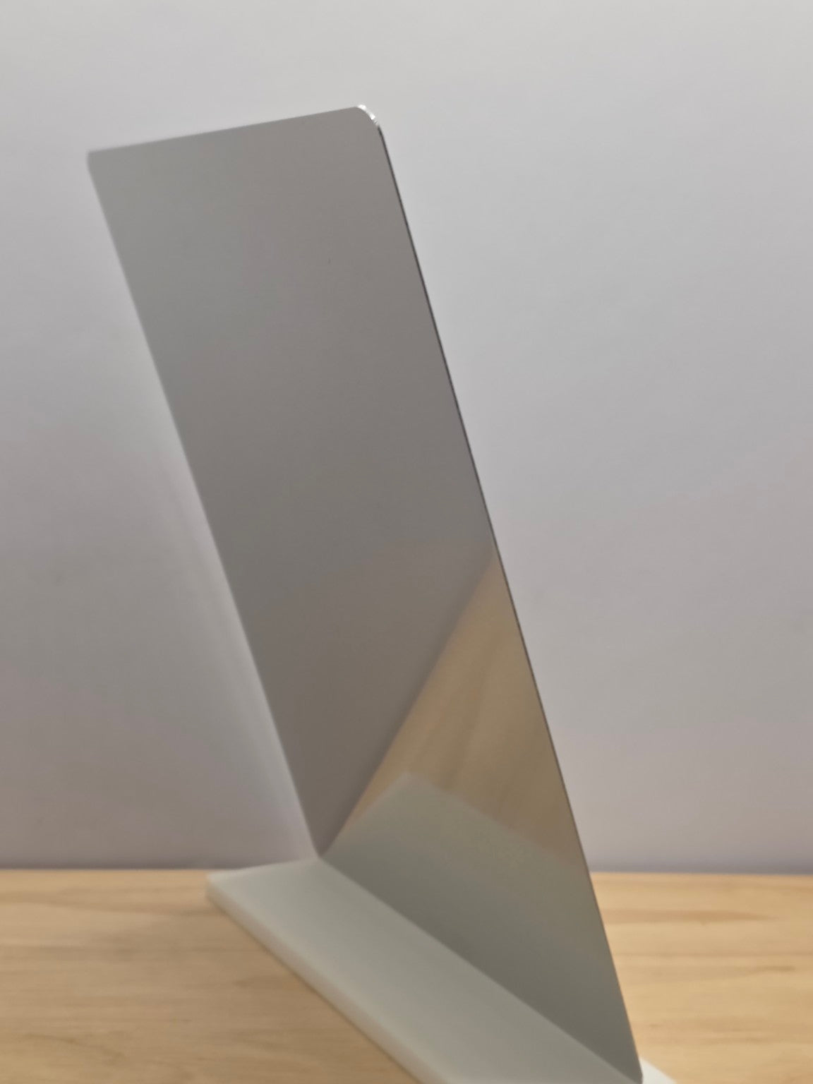 Side view of a portrait metal sign showing the metal back and white freestanding stand