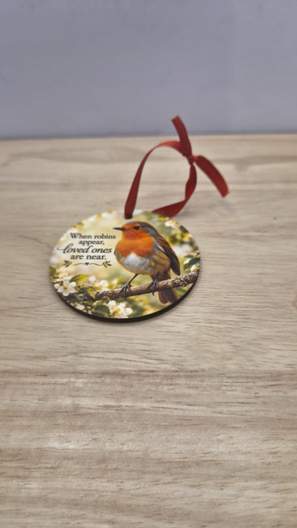Round robin memorial tree decoration with red ribbon and the words When robins appear, loved ones are near