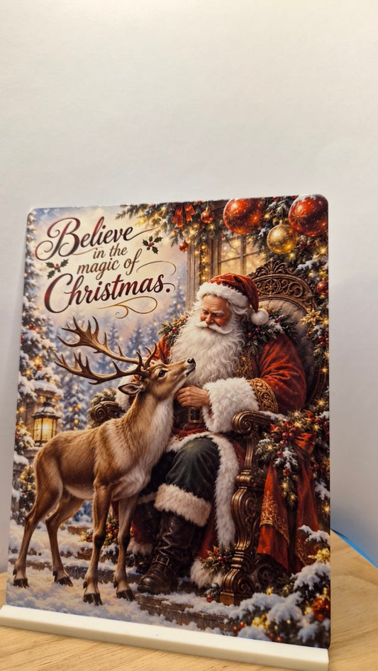 Believe in the Magic of Christmas metal sign with seated Father Christmas, a reindeer and the included white stand