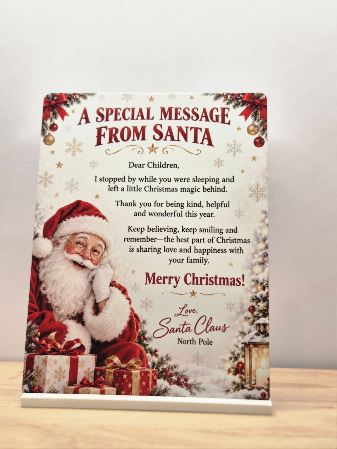 A Special Message from Santa metal sign with Father Christmas, holly and a Christmas morning message, displayed in a white stand