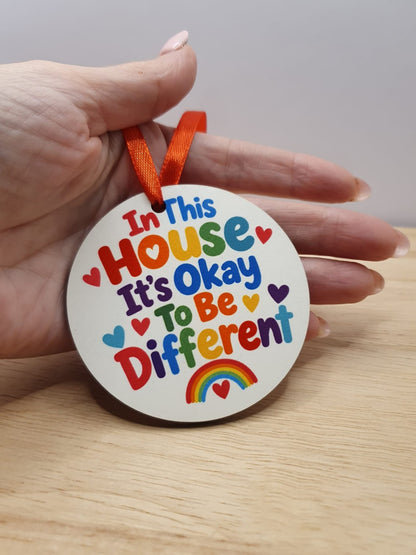 Colourful double-sided round hanging decoration sample showing personalised words in this house it is okay to be different
