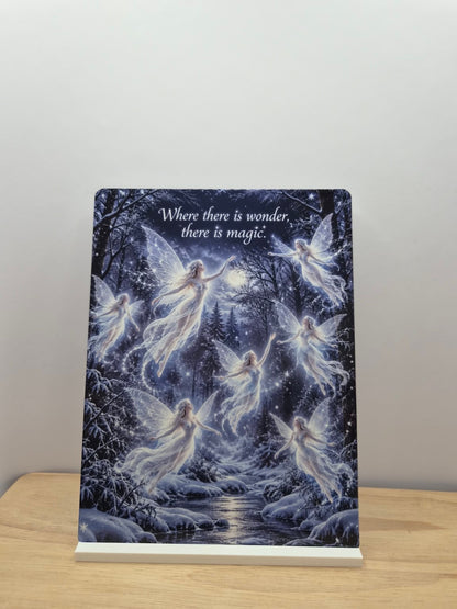 Where There Is Wonder fairy metal sign with a moonlit winter forest, glowing fairies and a stream, displayed in a white stand